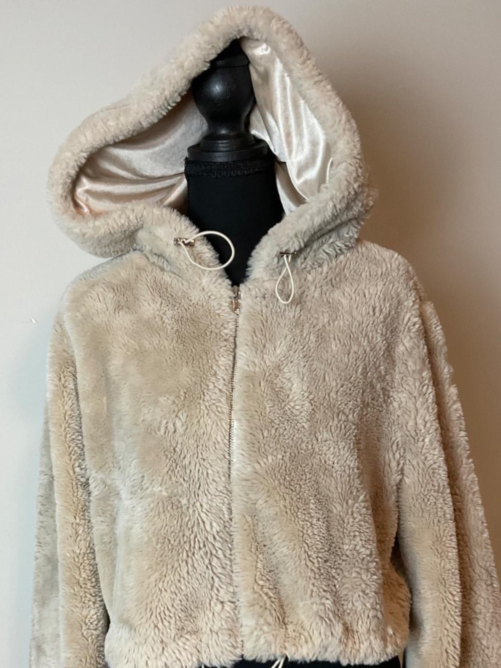 Cropped faux-fur teddy jacket/hoodie in a beige/cream color.